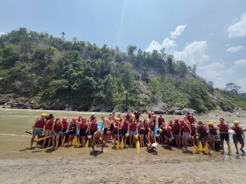 Happy rafting group gathered beside the Trishuli River in Nepal