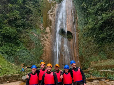 Travelers exploring a natural waterfall during Jalbire canyoning