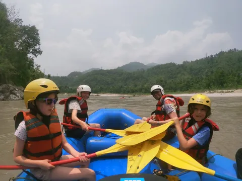 Parents and children enjoying a scenic whitewater journey on the Lower Seti