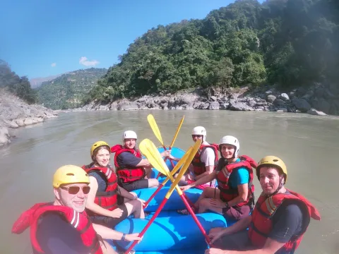 Adventurous travelers rafting through rapids on the Trishuli River