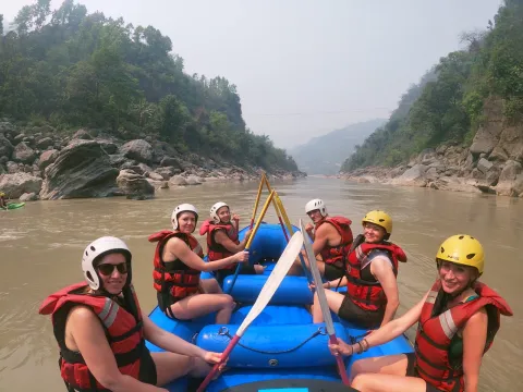 Rafters paddling together through scenic Karnali River whitewater