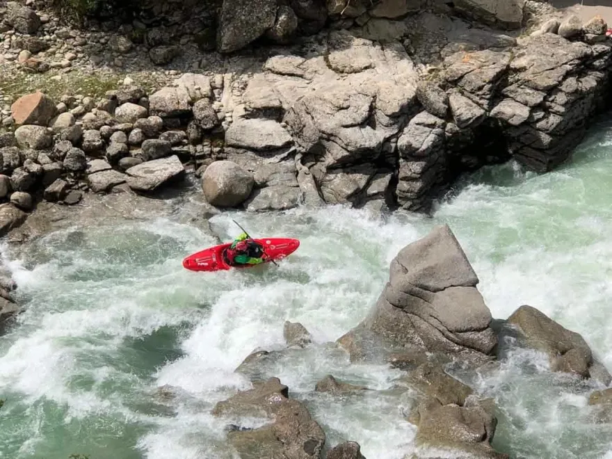 Kayaker paddling through Upper Seti River whitewater near Pokhara, Nepal